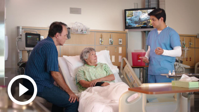 managing meds video woman in hospital bed with visitor and doctor